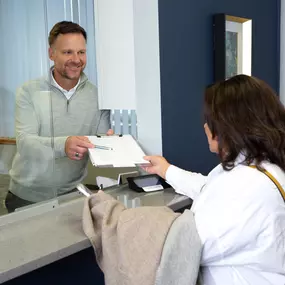 Matt Wilken (Founder & Audiologist) assists a patient