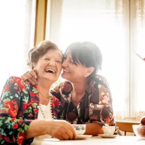 Senior Woman Enjoying a relaxing moment with her Daughter at Home drinking Coffee