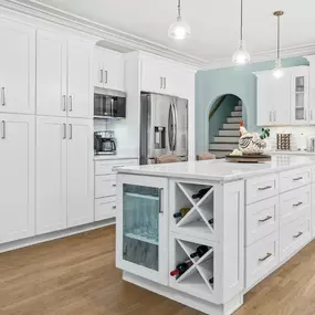 This clean white kitchen is far from boring with the splash of aqua blue walls and accents.