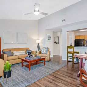 Open concept living room with wood style plank floors, updated lighted, and ceiling fans.