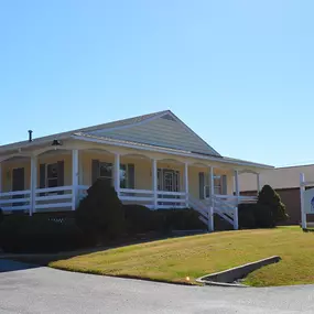 Front entrance of our Sutherland VA insurance agency office yellow clapbard sided building