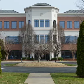 Front entrance of our Charlottesville NC insurance agency location three story red brick and stucco building