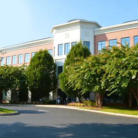 Front entrance of our Charlottesville NC insurance agency location three story red brick and stucco building