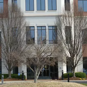 Front entrance of our Charlottesville NC insurance agency location three story red brick and stucco building