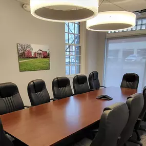 Conference room of our Albemarle, NC insurance agency office with long wood table surrounded by twelve chairs.