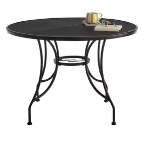 A round wrought iron outdoor dining table, perfect for al fresco dining or gathering with friends and family in the backyard or patio.