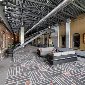 the lobby of a building with couches and a rug at The Knights @ 506 Delaware Apartments, Buffalo, NY 14202