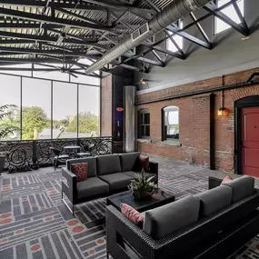a living room with couches and a red door at The Knights @ 506 Delaware Apartments, Buffalo, NY