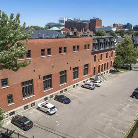 an aerial view of a brick building in a parking lot at The Knights @ 506 Delaware Apartments, Buffalo, New York