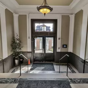a lobby with stairs and a glass door at The Knights @ 506 Delaware Apartments, New York, 14202