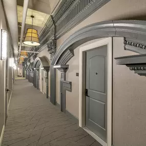 a hallway with white doors and a ceiling with a light fixture at The Knights @ 506 Delaware Apartments, Buffalo