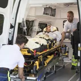 Mitarbeiter easyCab medical beim Ausladen eines Patienten auf dem Stryker