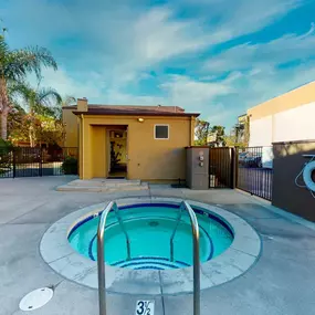 a small pool is in the middle of a house with a fence