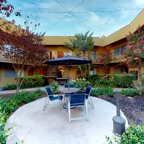 a patio with a table and chairs in a courtyard