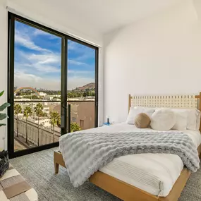 A bedroom with a large bed and a view of the city.