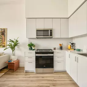 A modern kitchen with white cabinets and a stainless steel oven.