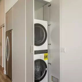 A row of white washing machines in a laundry room.