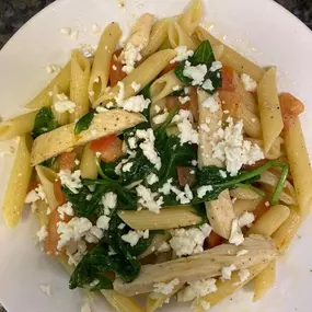 A plate of fresh pasta with creamy sauce and spinach is a lunch favorite prepared by Cranberry Hills Eatery & Catering in Phoenix, AZ.