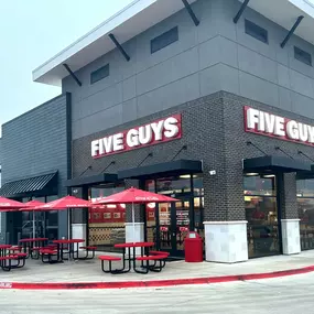 Exterior photograph of the Five Guys restaurant at 300 East Broad Street in Mansfield, Texas.