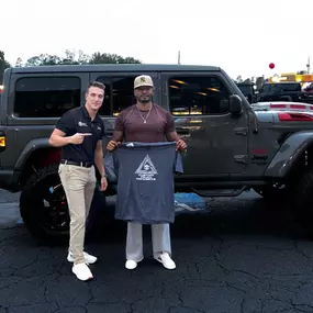 Customer standing outside of Custom Truck Concepts in Hattiesburg, Mississippi with their new Jeep. The top-rated off-road truck dealer and parts and accessories store.