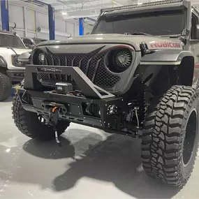 Inside view of Custom Truck Concepts in Hattiesburg, Mississippi showcasing a Jeep and truck inside the customization shop.