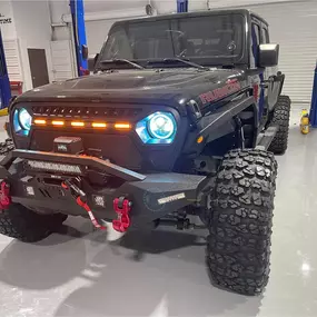 Inside view of Custom Truck Concepts in Hattiesburg, Mississippi, showcasing a customized Jeep with LED headlights.