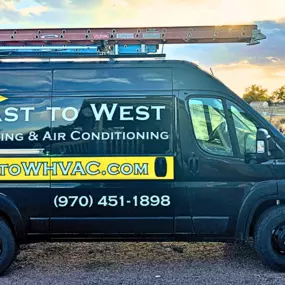 A branded East to West Heating & Air Conditioning service van parked in Greeley, CO, showcasing the company logo and contact information, ready to provide reliable furnace repair and heating services to local homes and businesses.