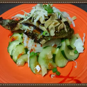 Wasabi - Sesame Encrusted Flounder served over rice and cucumber salad. Topped with sweet chili sauce and crispy wonton strips.