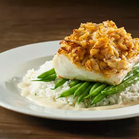 Crab-crusted haddock with crab cake, lemon butter sauce, herbed jasmine rice, and seasonal vegetable.