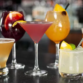 Assorted cocktails lined up along the bar.