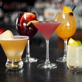 Assorted cocktails lined up along the bar.