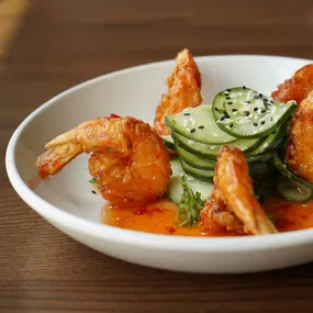 Crispy colossal shrimp, firecracker sauce, sesame, and cilantro cucumber salad.