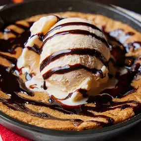 Skillet cookie with vanilla ice cream and chocolate sauce.