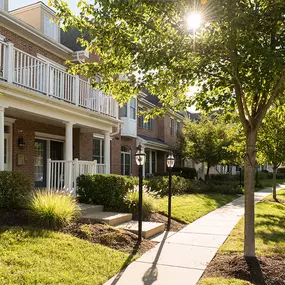 A tree-lined pathway near Claremont Apartments 2-story apartment building.