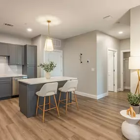 A modern kitchen with a dining area and a living area.