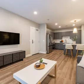 A modern living room with a white coffee table and grey couch.