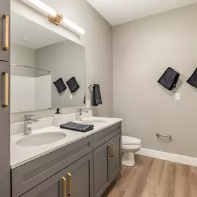 A bathroom with a sink, toilet, and mirror.