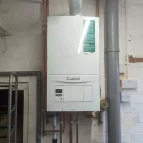 White Vaillant boiler installed with copper piping in a utility area.