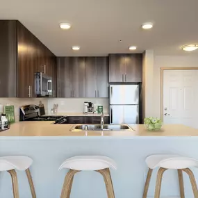 a kitchen with a counter top with three stools