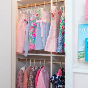 children's closet in white with matte gold closet rods. This doubles the hanging space.