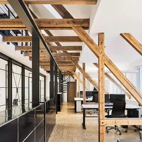 Ein inspirierender Coworking Space in der Alten Stadtkasse Oldenburg, kombiniert mit sichtbaren Dachbalken und moderner Büroeinrichtung. Die offene Raumgestaltung und der Einsatz natürlicher Materialien schaffen eine einzigartige Arbeitsatmosphäre. Flexible Arbeitsplätze bieten eine ideale Umgebung für Teams und Einzelpersonen.