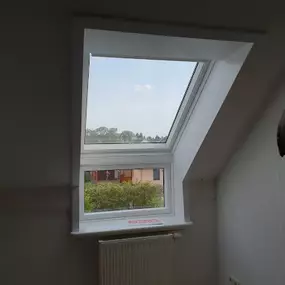 Ein frisch installiertes Dachfenster, das einen klaren Blick auf die Umgebung bietet. Ideal für mehr Licht in kleinen Räumen.