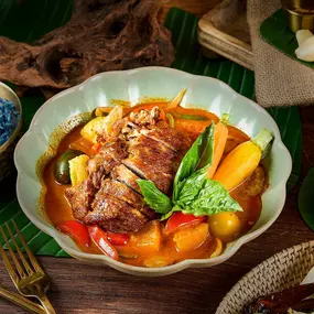 Roasted duck breast simmered in red curry paste with coconut milk, baby eggplant, pineapple, mushrooms, and seasonal vegetables served with blue coconut rice.