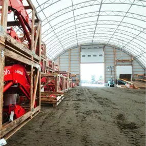 Interior view of a Pilot Buildings arched structure utilized as a warehouse for storing crated machinery components.