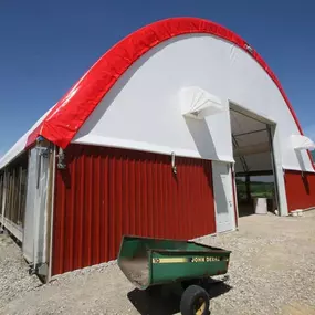 Exterior view of a Pilot Buildings structure combining an arched fabric roof with metal siding on the end and side walls.