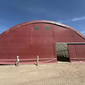 Pilot Buildings showcases a completed fabric building re-covering project. This arena now features a durable, new HDPE red fabric cover, giving it a renewed appearance and extended lifespan. We revitalize aging structures.