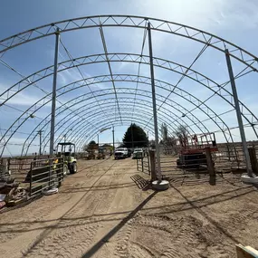 Pilot Buildings mid-project on a fabric arena re-cover. We expertly remove old covers and install new, high-quality HDPE fabric, available in various colors like the red chosen for this arena's end walls.