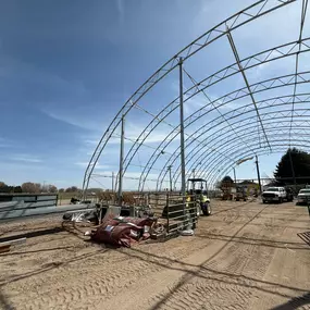 Re-covering in progress by Pilot Buildings. This 27-year-old arena frame is being prepared for new, durable HDPE fabric. We offer various color options, including the red end walls chosen for this project.
