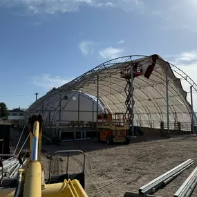 Progress continues on the arena re-cover by Pilot Buildings. Our experienced team installs durable HDPE fabric covers, available in various colors, ensuring a quality finish for revitalized structures.