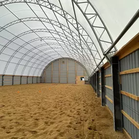 Pilot Buildings offers customizable fabric structures tailored to your needs. This interior view showcases a design combining durable lower walls with a bright, clear-span fabric roof, ideal for arenas or multi-use facilities.